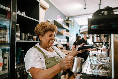 Barista smiling whilst making coffee