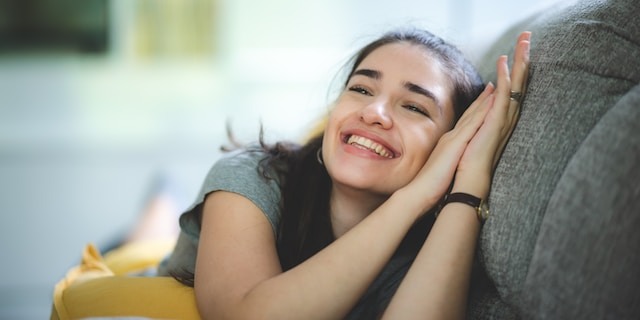 Young person relaxing on coach smiling