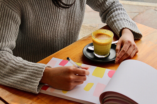 Person sitting at café studying and drinking coffee