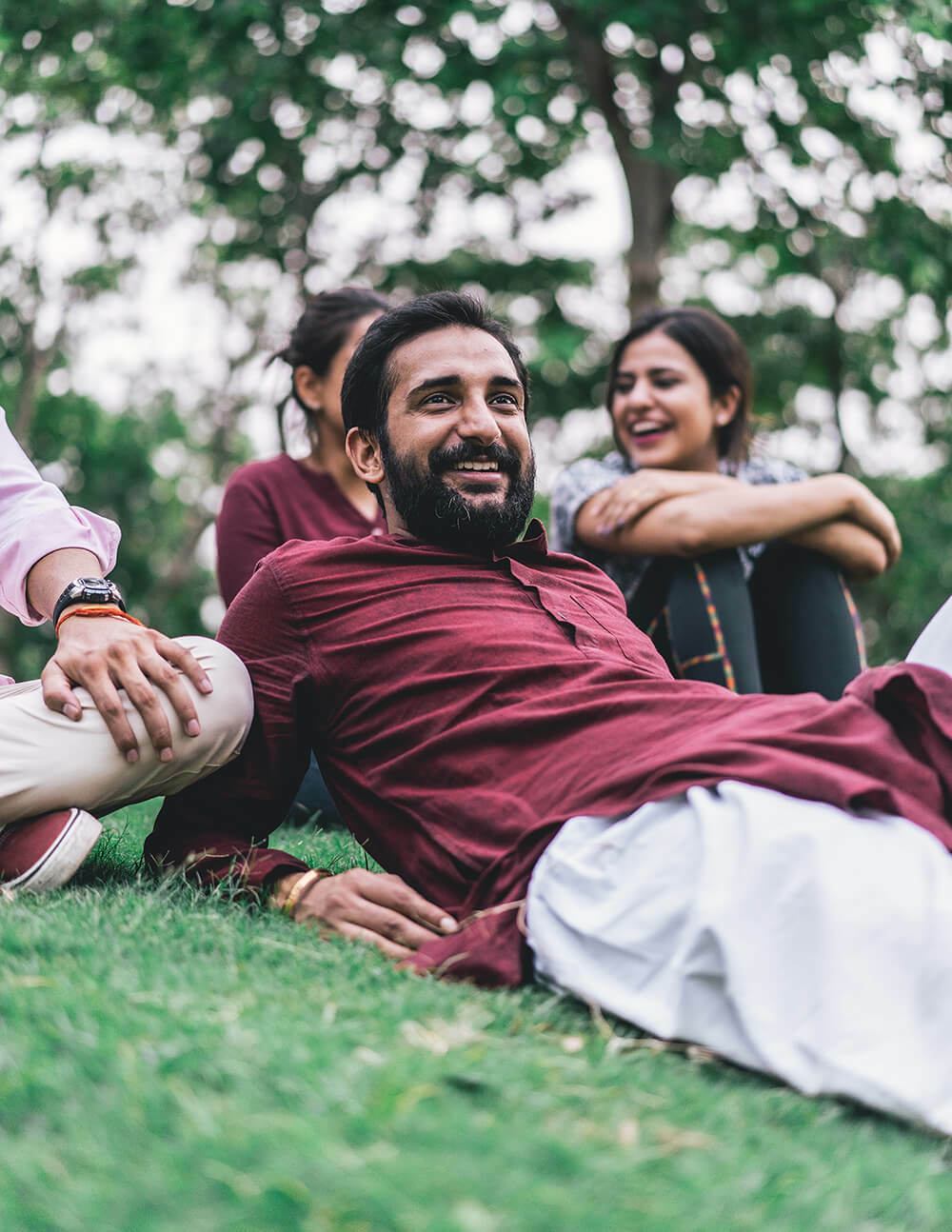 Man laying down on grass chatting with friends