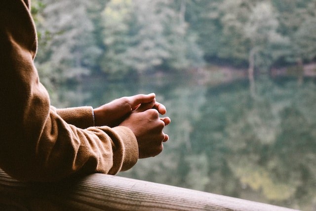 Person standing next to river looking into the distance