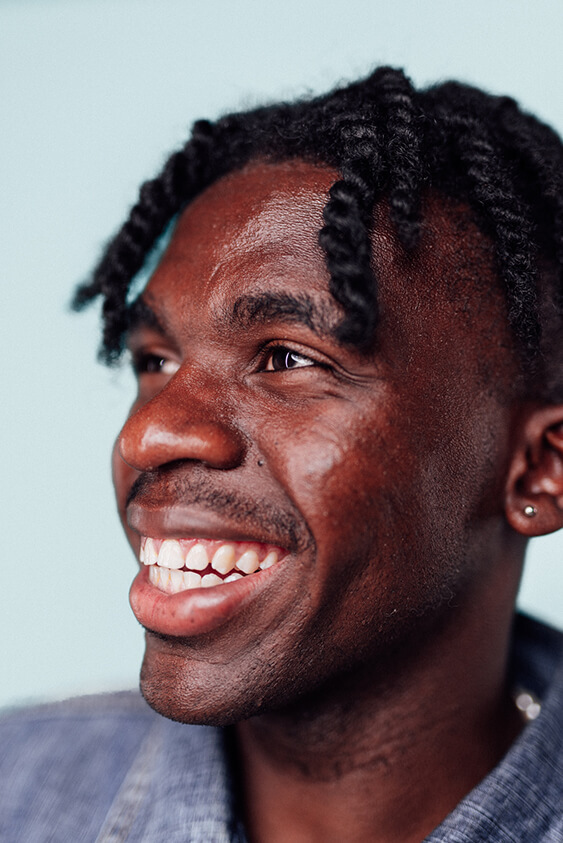 Portrait of young man smiling close up with blue background