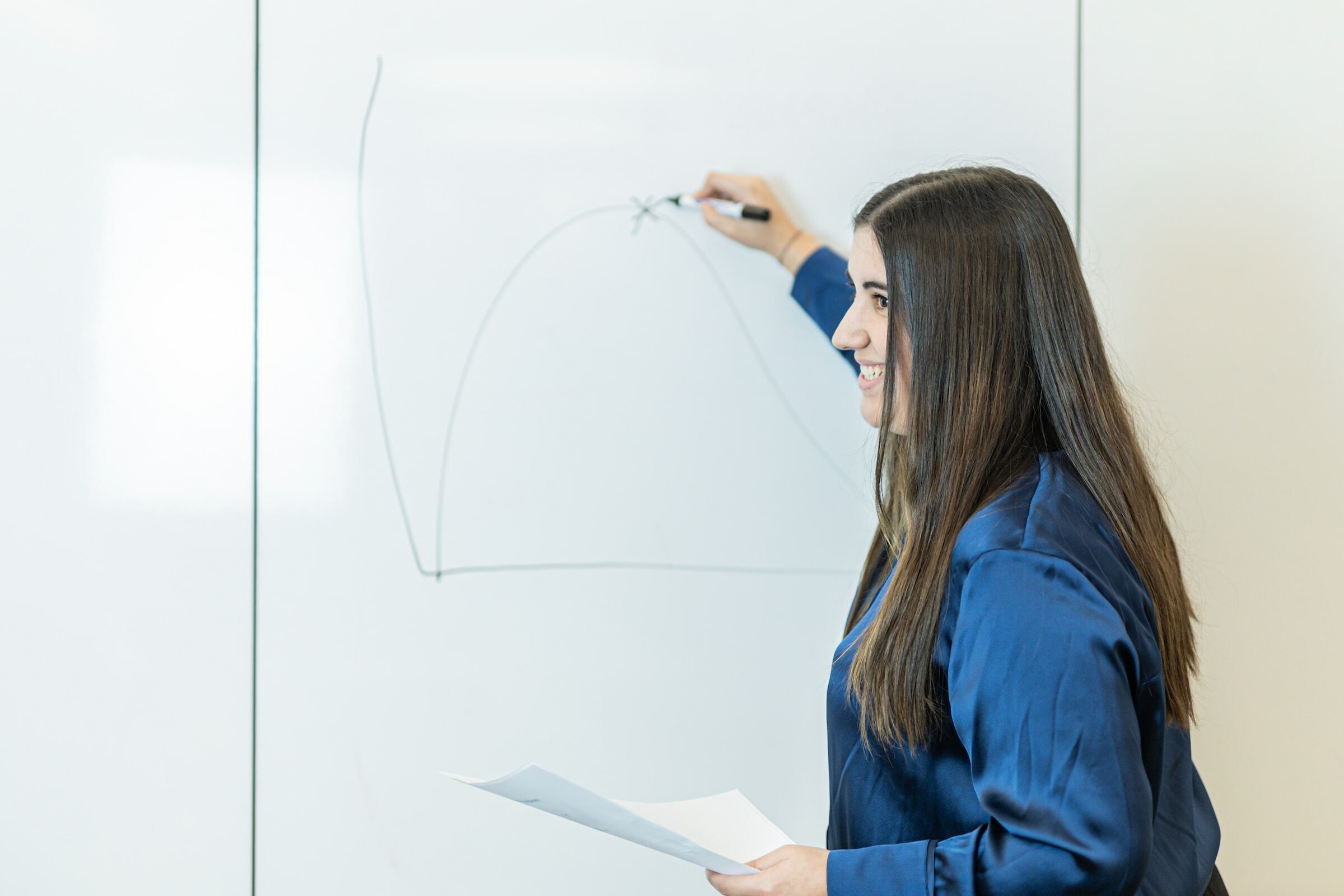 Trainer writing on whiteboard in class