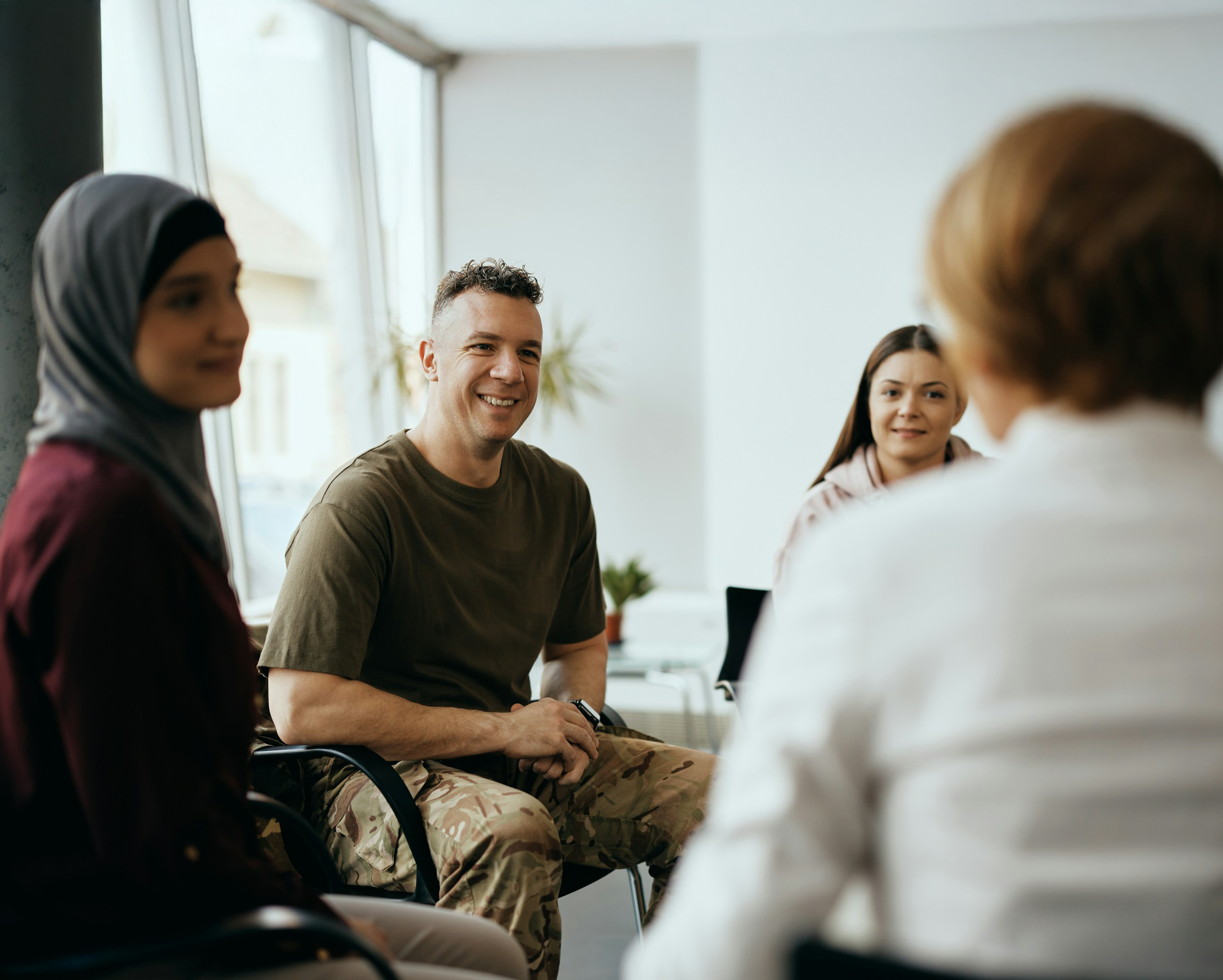 Small group of people sitting together and talking during a meeting.